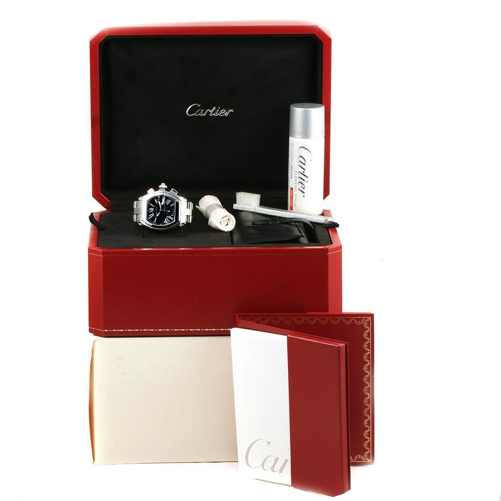 The image shows a Cartier Roadster W62020X6 Men's Stainless Steel Black Dial W62020X6 Men's Stainless Steel Black Dial watch with its accessories and packaging, including a cleaning kit, in an open box.