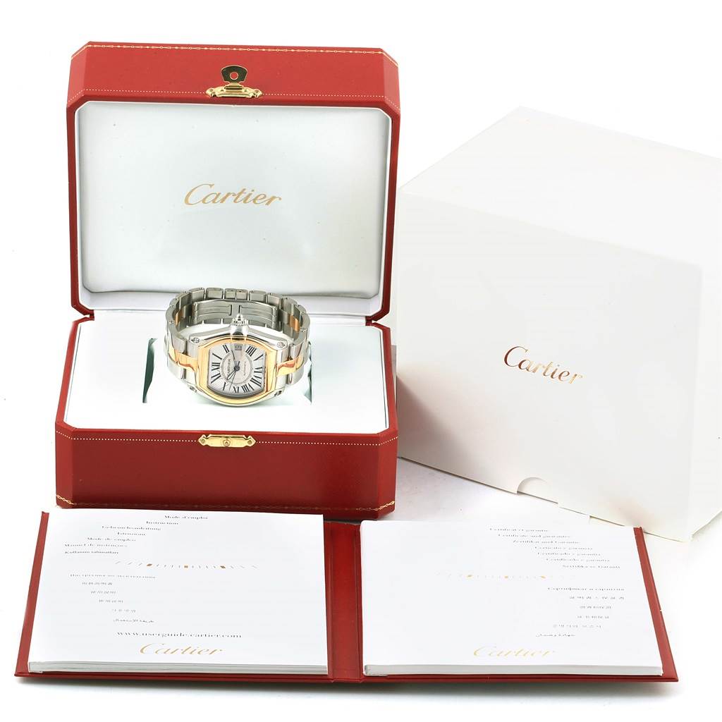 The Cartier Roadster W62031Y4 Men's Steel and Gold (two tone) Silver Dial W62031Y4 Men's Steel and Gold (two tone) Silver Dial model watch is displayed in an open red box, positioned at a front angle, with booklets in front and packaging behind.