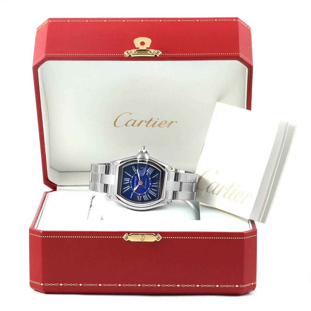 The Cartier Roadster W62048V3 Men
s Stainless Steel Blue Dial W62048V3 Men
s Stainless Steel Blue Dial watch is shown inside its open red box with a visible information booklet.