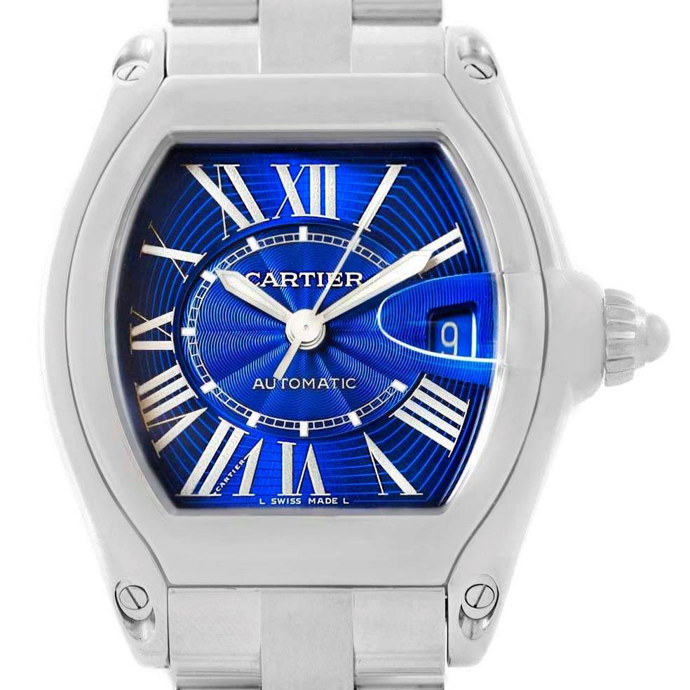 The image shows a frontal view of the Cartier Roadster W62048V3 Men
s Stainless Steel Blue Dial W62048V3 Men
s Stainless Steel Blue Dial watch, highlighting its blue dial, Roman numerals, date window, and stainless steel bracelet.