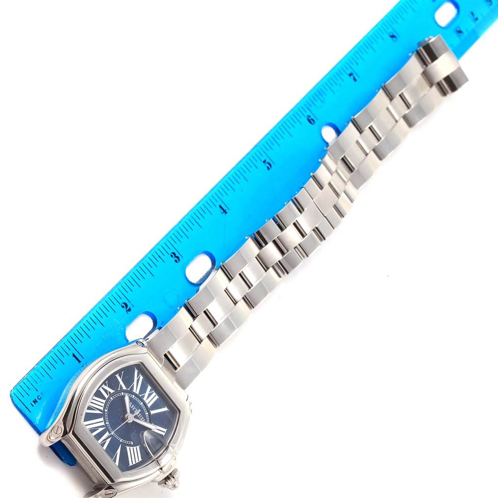 The image shows a Roadster model watch by Cartier, featuring its face, strap, and a ruler for scale.