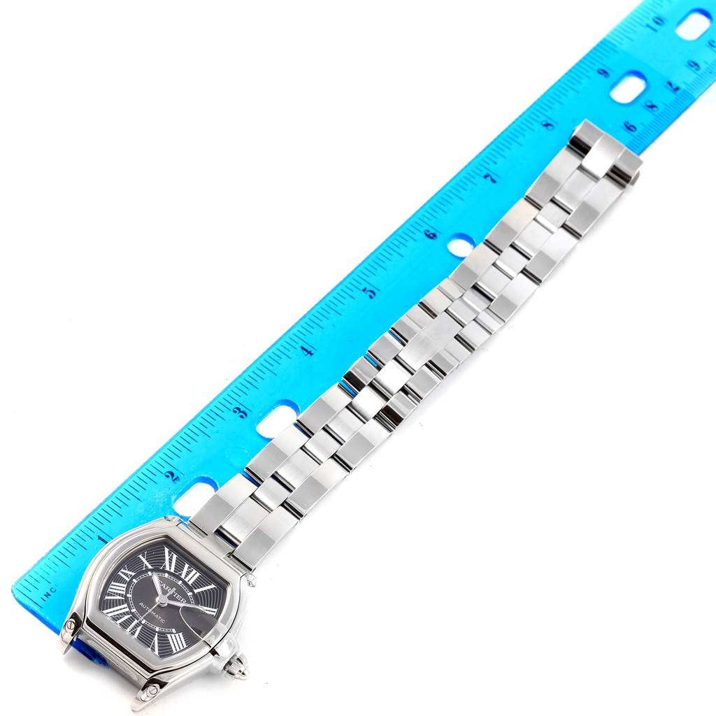 The Cartier Roadster W62041V3 Men
s Stainless Steel Black Dial W62041V3 Men
s Stainless Steel Black Dial watch is shown from a top-down angle, featuring the face and the entire length of the metal bracelet alongside a ruler.