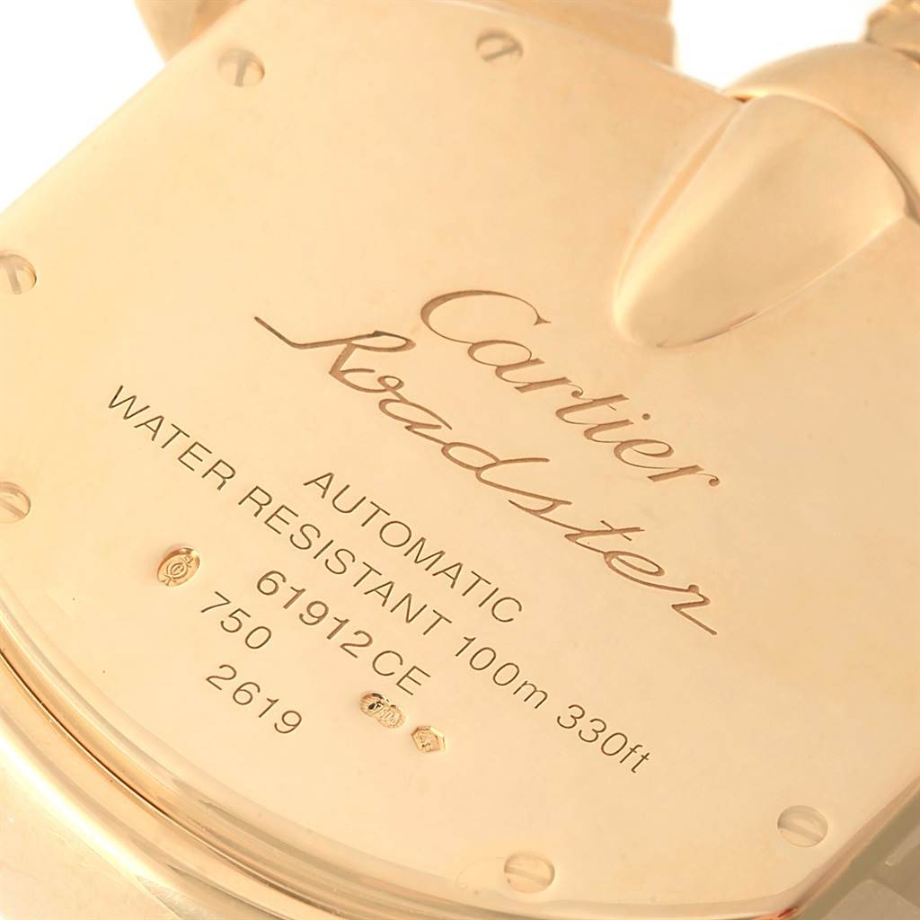 The image shows a close-up of the back case of a Cartier Roadster W62021Y2 Men's Yellow Gold Silver Dial W62021Y2 Men's Yellow Gold Silver Dial watch, highlighting its engravings and details.