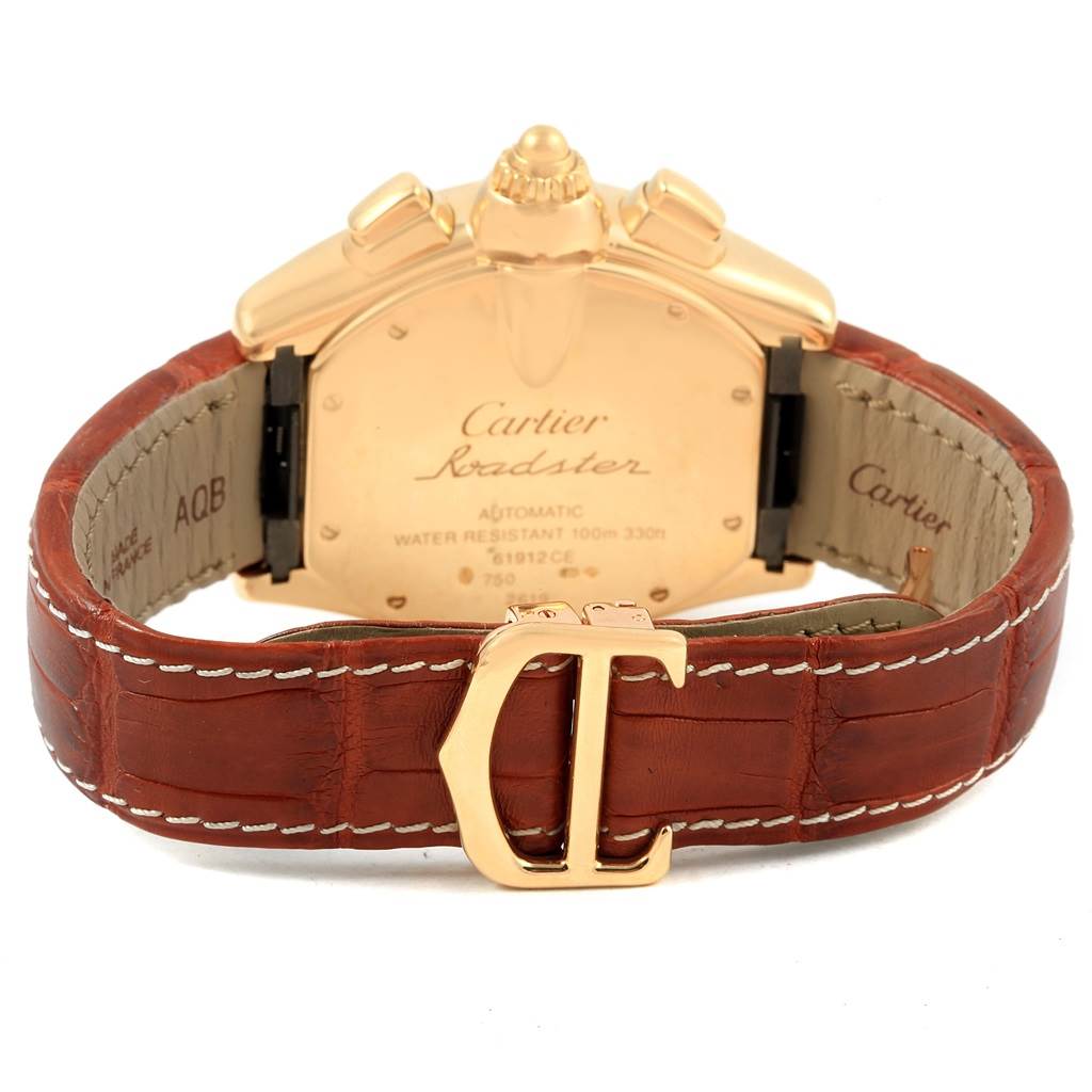 The image shows the back view of a Cartier Roadster W62021Y2 Men's Yellow Gold Silver Dial W62021Y2 Men's Yellow Gold Silver Dial watch featuring a leather strap and a gold clasp with the Cartier logo.