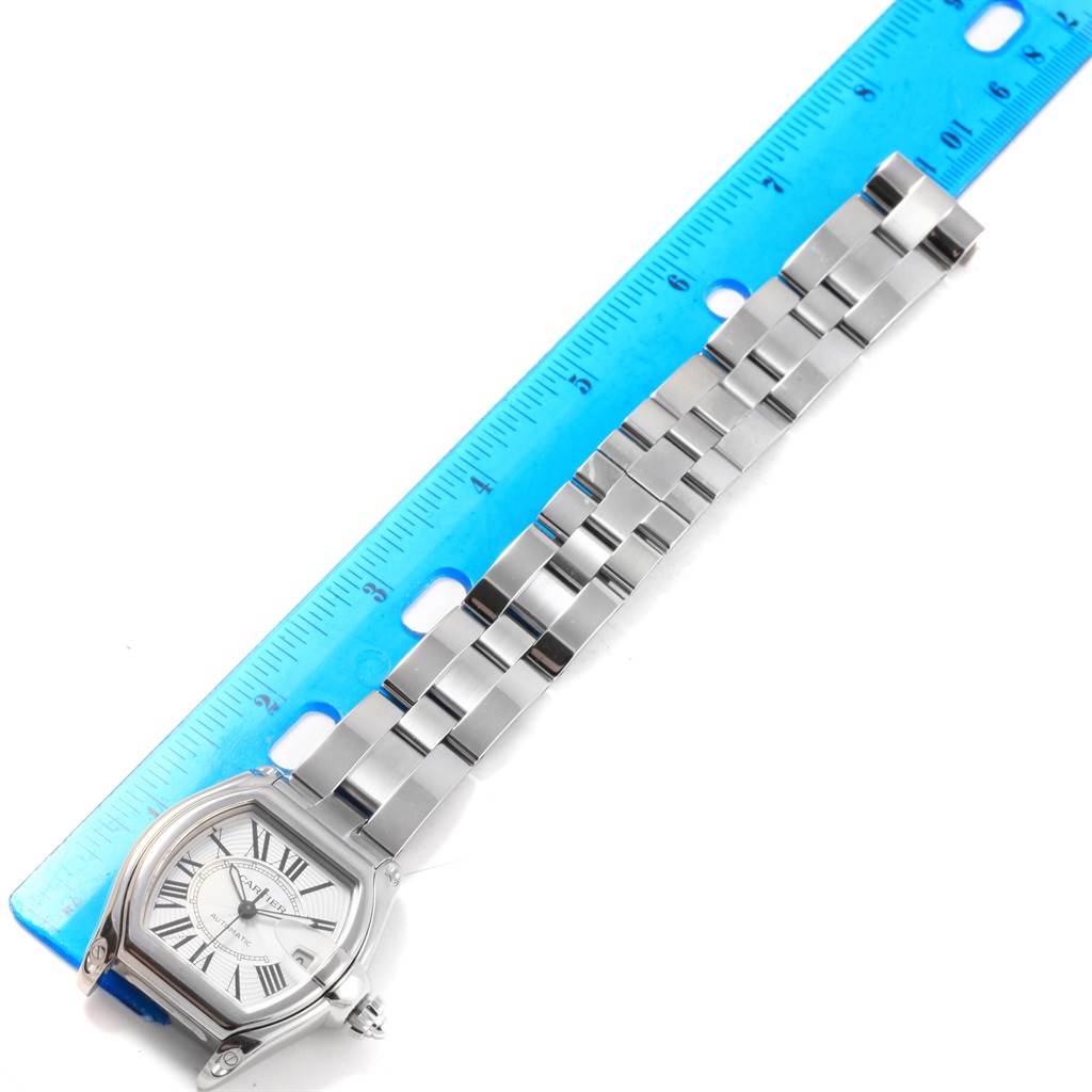 The image shows a top-down angle of a Cartier Roadster W62025V3 Men's Stainless Steel Silver Dial W62025V3 Men's Stainless Steel Silver Dial watch, including the face and entire metal bracelet, next to a ruler.
