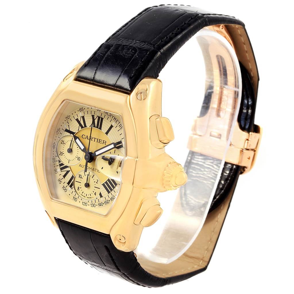 The Cartier Roadster W62021Y3 Men's Yellow Gold Champagne Dial W62021Y3 Men's Yellow Gold Champagne Dial watch is shown from a three-quarter angle, highlighting the gold case, black leather strap, and side buttons.