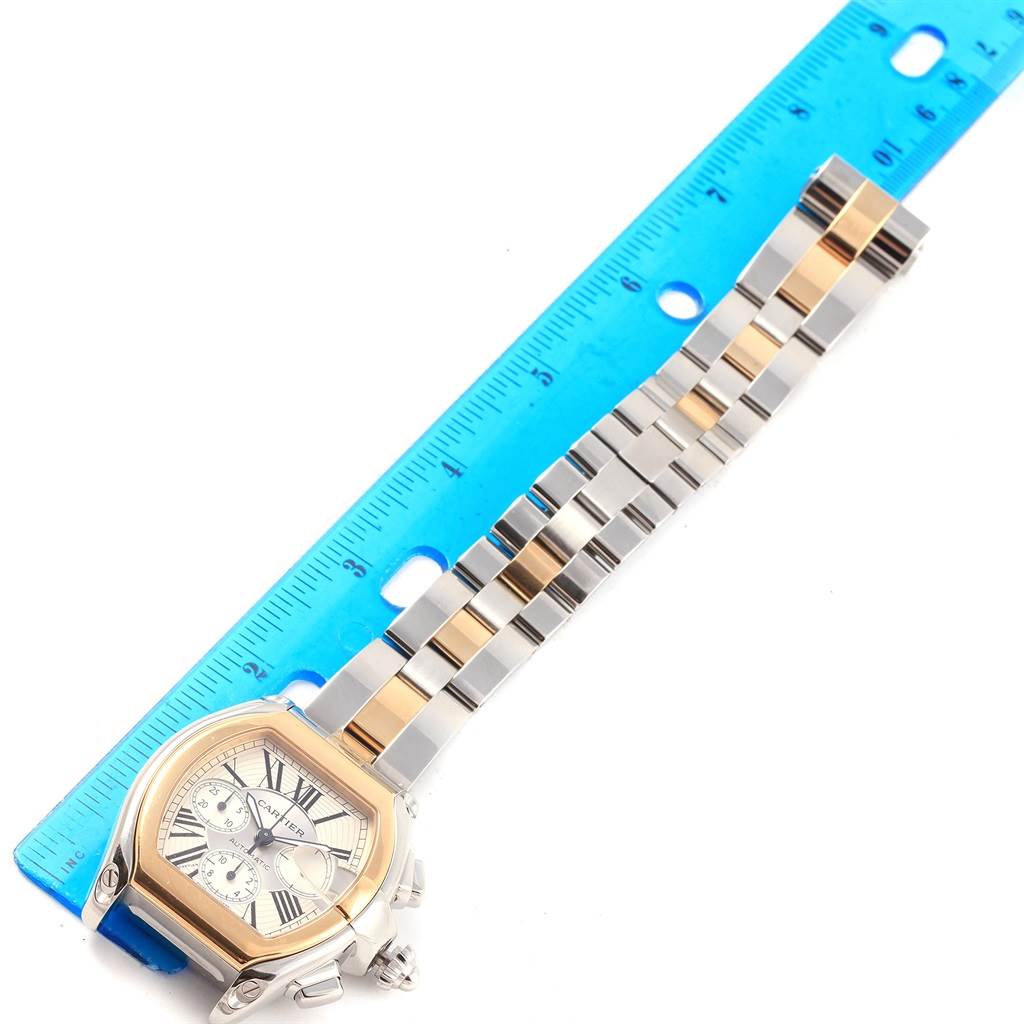 The image shows a top view of the Cartier Roadster W62027Z1 Men
s Steel and Gold (two tone) Silver Dial W62027Z1 Men
s Steel and Gold (two tone) Silver Dial watch, highlighting its face, bezel, and part of the bracelet alongside a ruler.