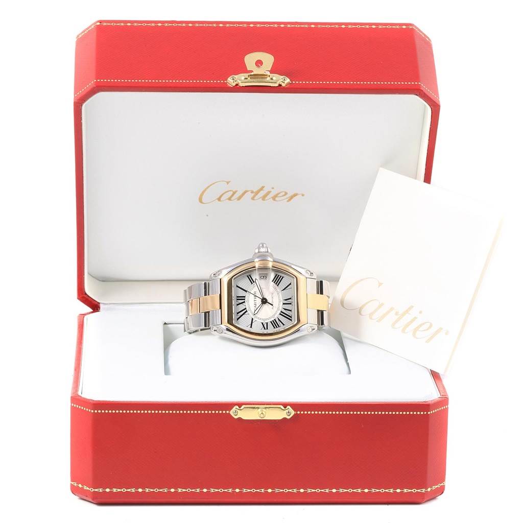 The Cartier Roadster W62031Y4 Men's Steel and Gold (two tone) Silver Dial W62031Y4 Men's Steel and Gold (two tone) Silver Dial watch is shown front-on, in its open box with a booklet beside it.