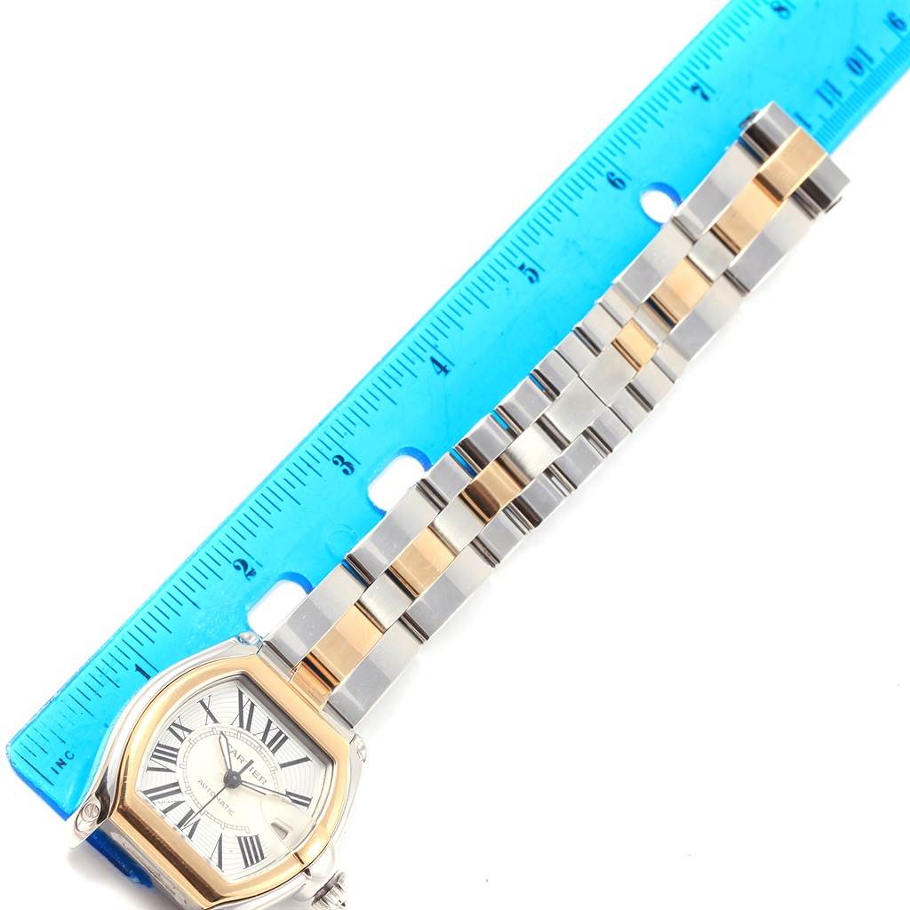 The image shows a Cartier Roadster W62031Y4 Men's Steel and Gold (two tone) Silver Dial W62031Y4 Men's Steel and Gold (two tone) Silver Dial watch with a measurement ruler next to its two-tone metal bracelet.