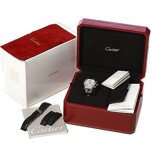 The image shows a Cartier Roadster W62020X6 Men's Stainless Steel Silver Dial W62020X6 Men's Stainless Steel Silver Dial watch in its open presentation box, with a spare strap and accompanying paperwork displayed nearby.