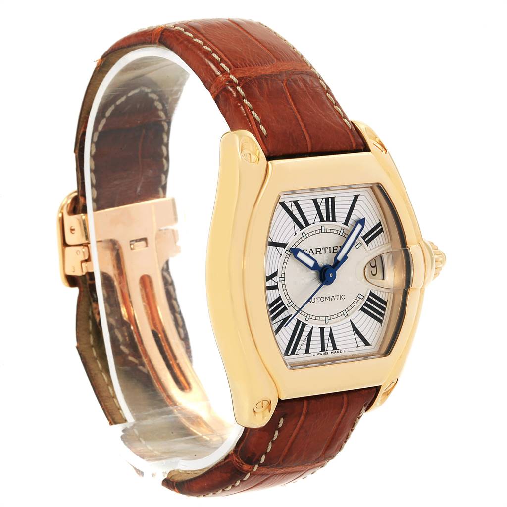 The Cartier Roadster W62005V2 Men's Yellow Gold Silver Dial W62005V2 Men's Yellow Gold Silver Dial watch is shown at a slight angle, highlighting its gold case, brown leather strap, and detailed face.