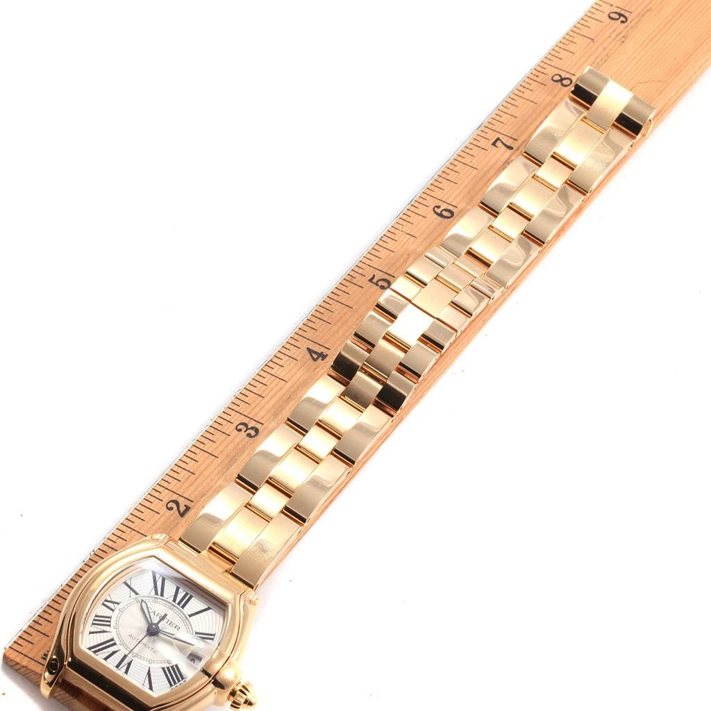 The image shows a Cartier Roadster W62005V1 Men's Yellow Gold Silver Dial W62005V1 Men's Yellow Gold Silver Dial watch lying flat, with the face and gold metal band measured by a wooden ruler.