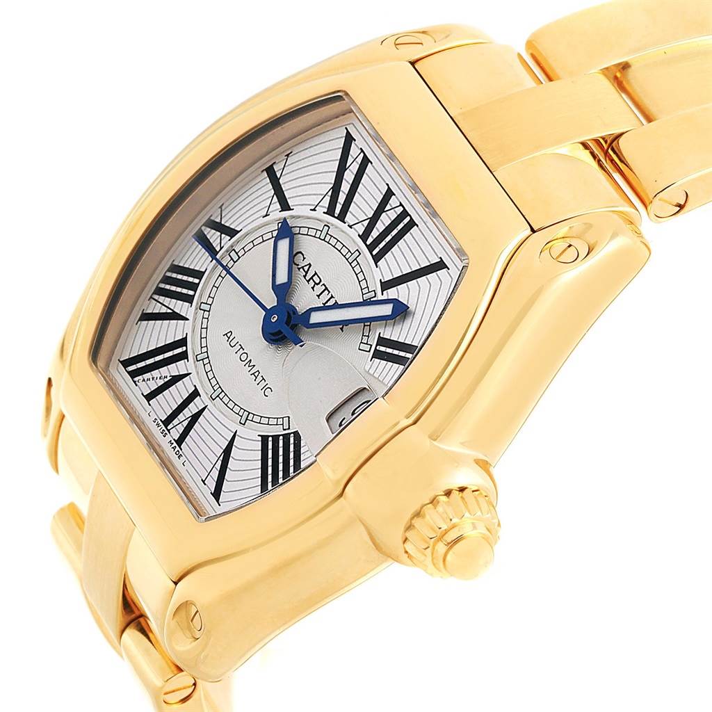 The image shows the Cartier Roadster W62005V1 Men's Yellow Gold Silver Dial W62005V1 Men's Yellow Gold Silver Dial watch at an angle highlighting its face, crown, and part of the bracelet.