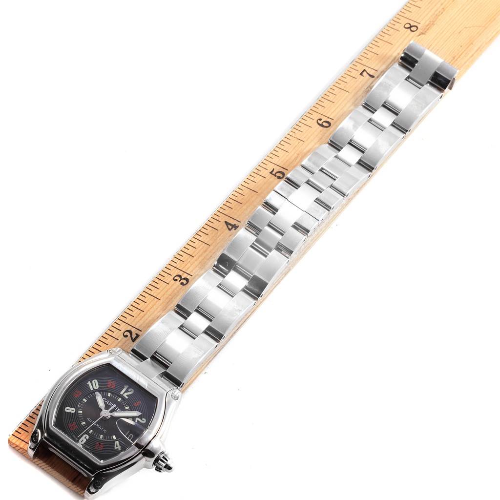 The Cartier Roadster W62002V3 Men
s Stainless Steel Black Dial W62002V3 Men
s Stainless Steel Black Dial watch is shown from a top-down angle, highlighting its face and metal bracelet laid against a ruler.