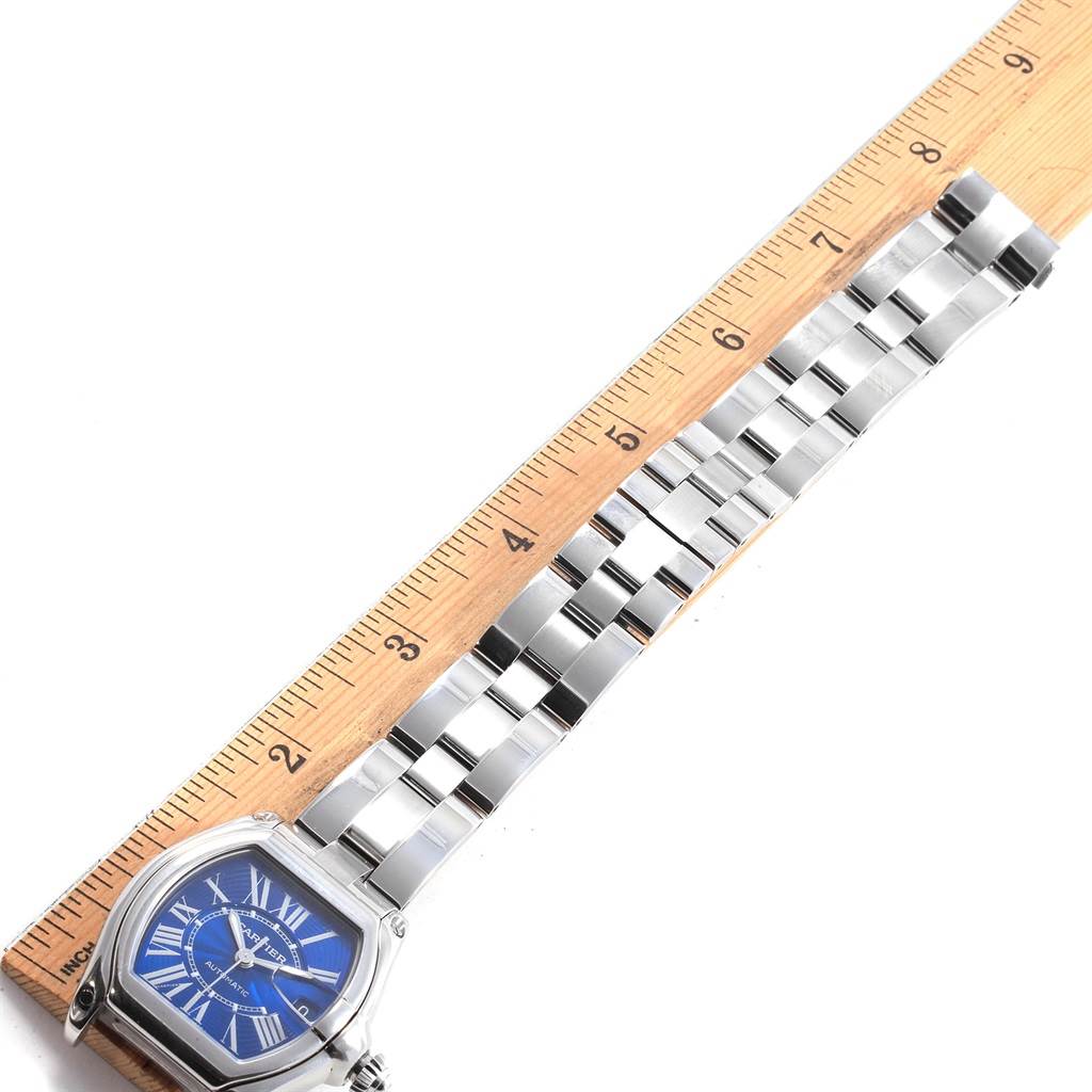 The Cartier Roadster W62048V3 Men's Stainless Steel Blue Dial W62048V3 Men's Stainless Steel Blue Dial watch is shown flat with a clear view of its blue dial and metal bracelet next to a ruler.