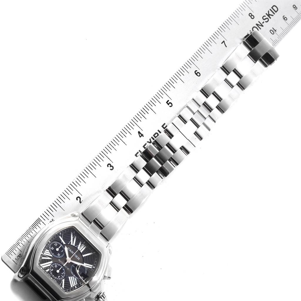 The image shows the Cartier Roadster W62020X6 Men's Stainless Steel Black Dial W62020X6 Men's Stainless Steel Black Dial watch face and its metal bracelet band, positioned next to a ruler for measurement.