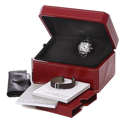 The image shows a Cartier Roadster W62019X6 Men's Stainless Steel Silver Dial W62019X6 Men's Stainless Steel Silver Dial watch in an open red case, a leather strap, booklets, and a black leather pouch from a front perspective.