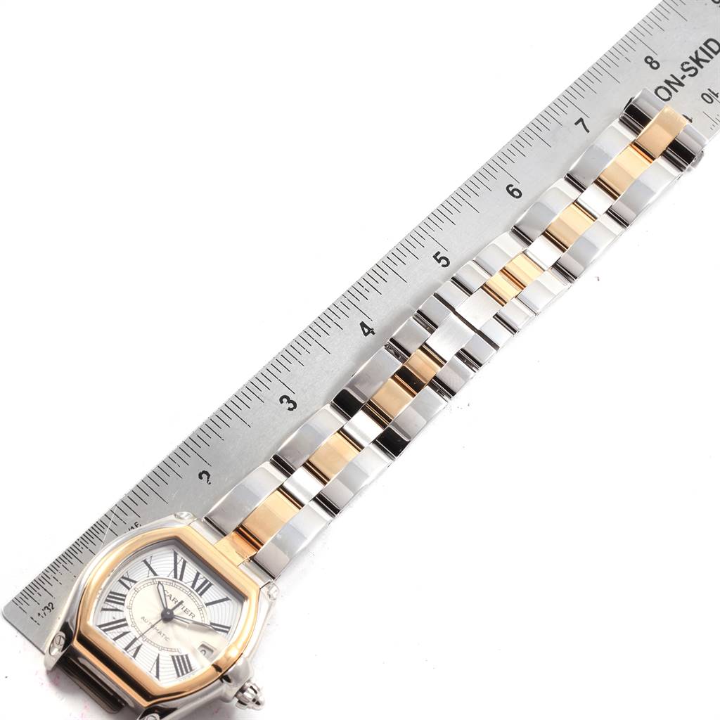 The Cartier Roadster W62031Y4 Men
s Steel and Gold (two tone) Silver Dial W62031Y4 Men
s Steel and Gold (two tone) Silver Dial watch is shown from a top-down angle, highlighting the face and the bracelet with a ruler for scale.