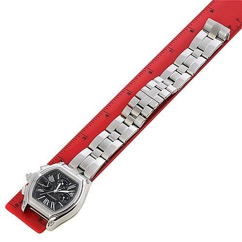 The image shows a Cartier Roadster W62020X6 Men's Stainless Steel Black Dial W62020X6 Men's Stainless Steel Black Dial watch laid flat on a red ruler, viewed from above.