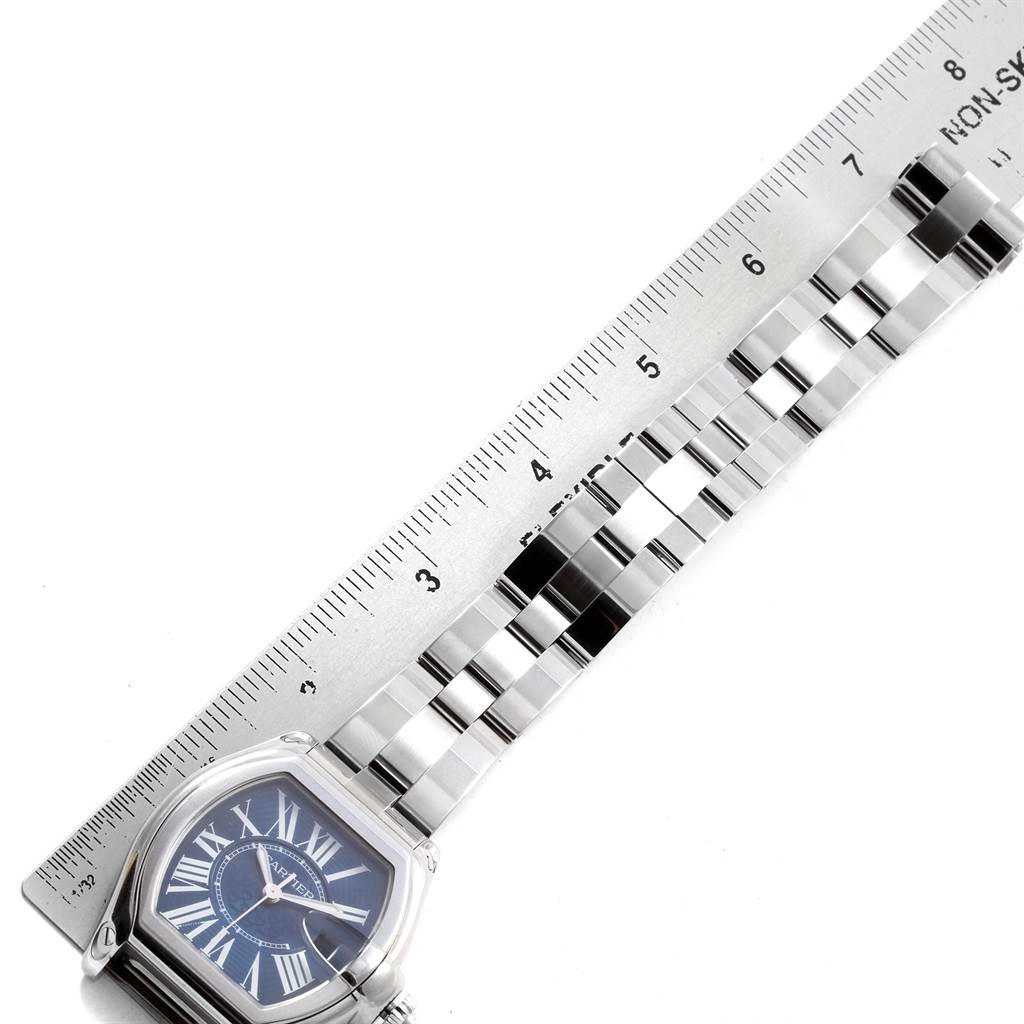 The image shows the face and part of the bracelet of a Cartier Roadster W6206012 Men
s Stainless Steel Blue Dial W6206012 Men
s Stainless Steel Blue Dial watch, alongside a ruler for scale.