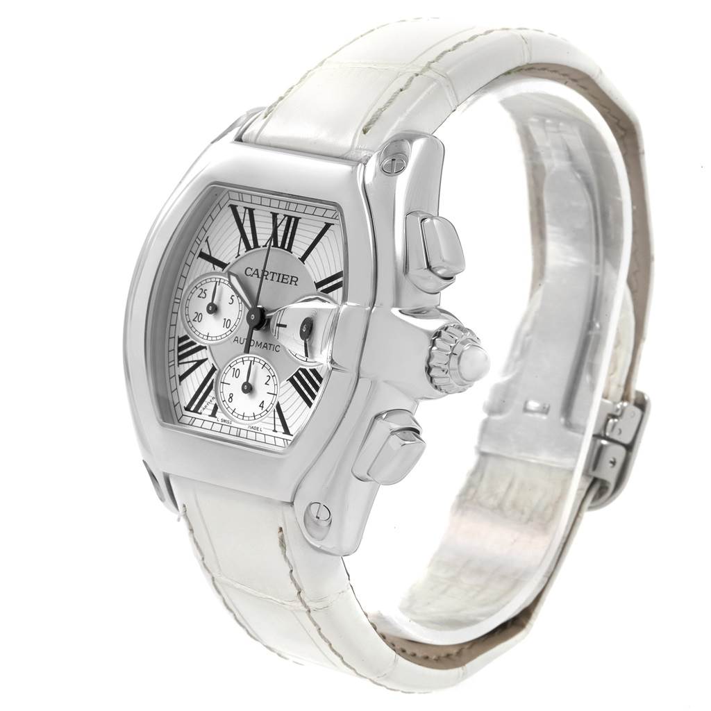 The image shows the Cartier Roadster W62019X6 Men
s Stainless Steel Silver Dial W62019X6 Men
s Stainless Steel Silver Dial watch from a three-quarter angle, highlighting its white dial, chronograph, and white leather strap.