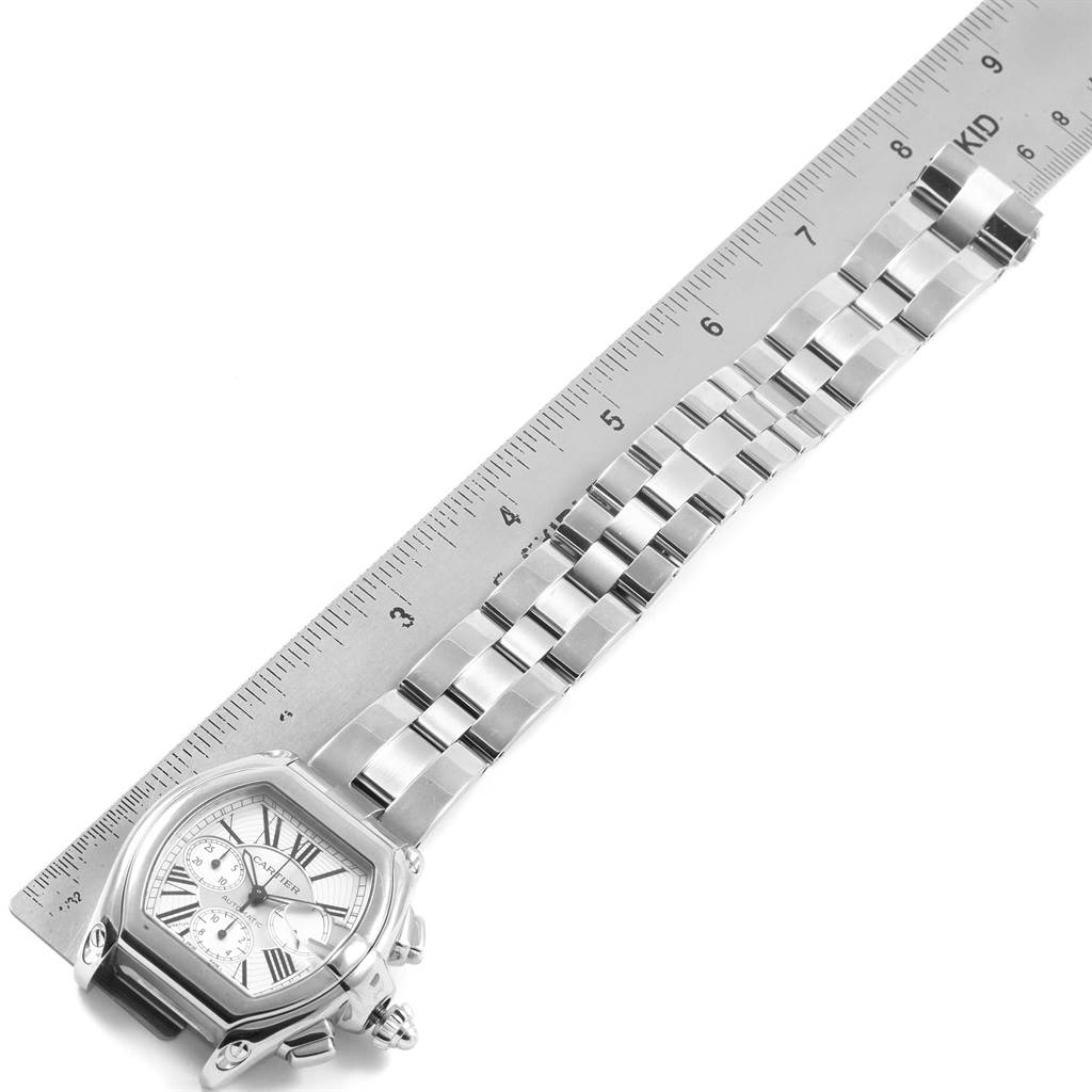 This image shows a Cartier Roadster W62019X6 Men's Stainless Steel Silver Dial W62019X6 Men's Stainless Steel Silver Dial watch laid flat with its face and entire band fully visible next to a ruler for scale.