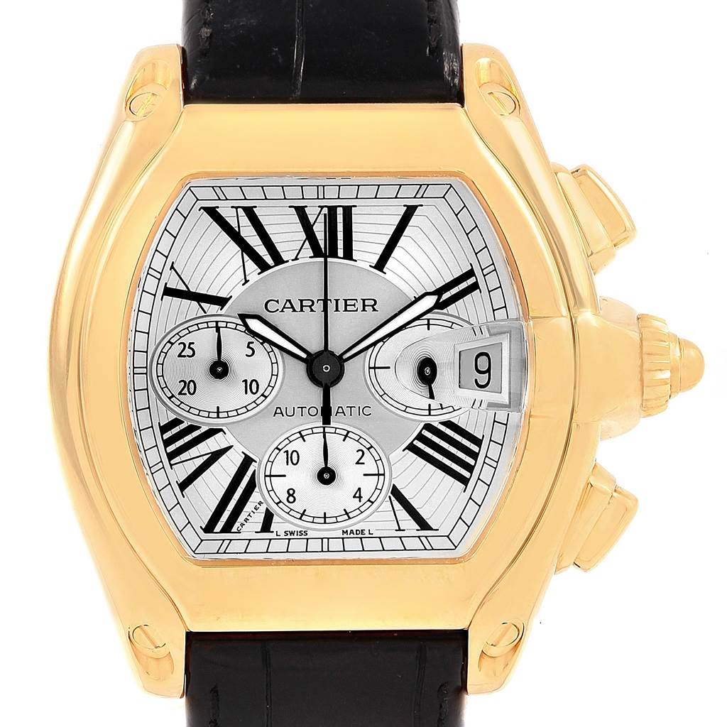 The image shows a frontal view of a Cartier Roadster W62021Y3 Men's Yellow Gold Silver Dial W62021Y3 Men's Yellow Gold Silver Dial watch, featuring its dial, date window, and chronograph subdials.