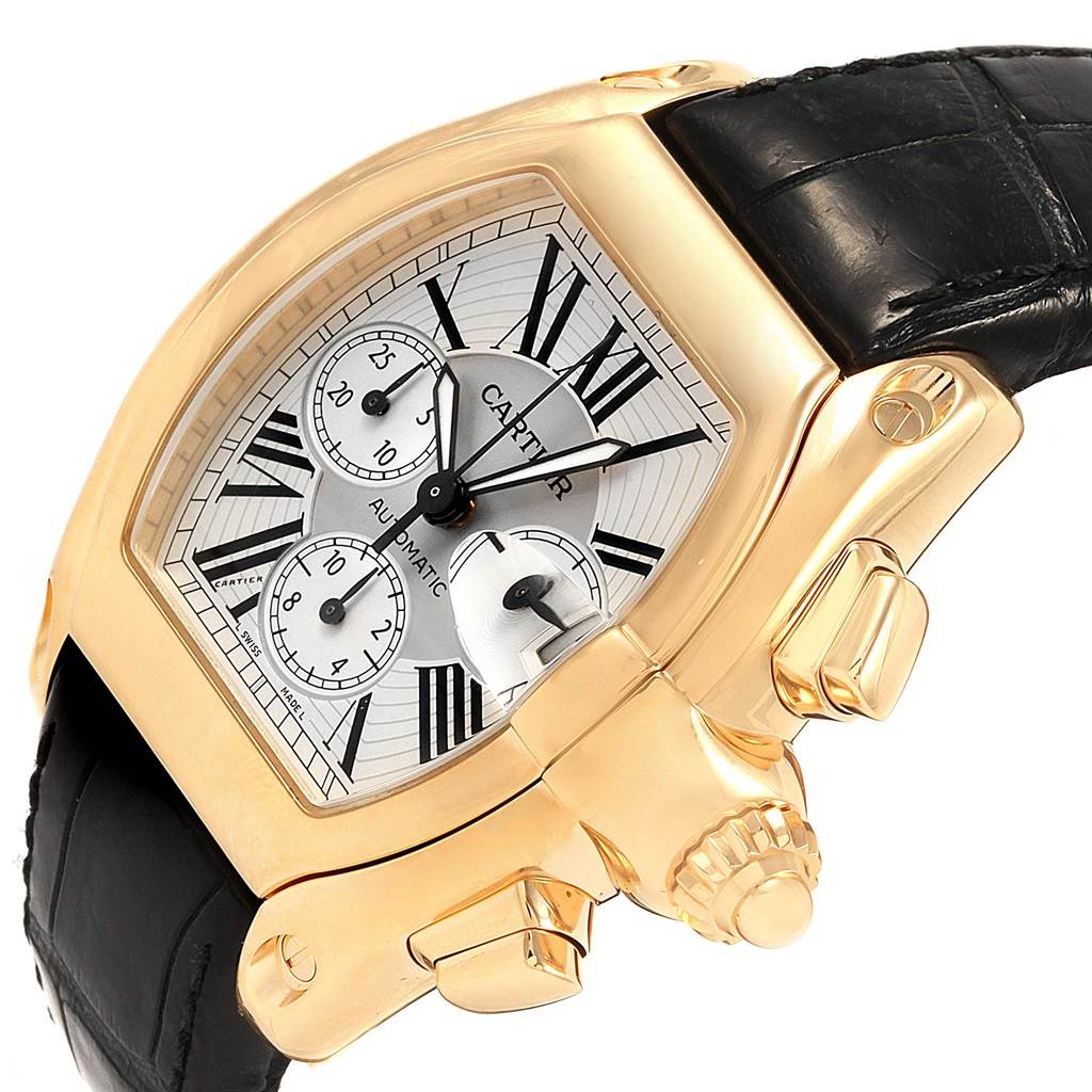 The image shows a Cartier Roadster W62021Y3 Men's Yellow Gold Silver Dial W62021Y3 Men's Yellow Gold Silver Dial watch at an oblique angle highlighting the watch face, crown, and black leather strap.