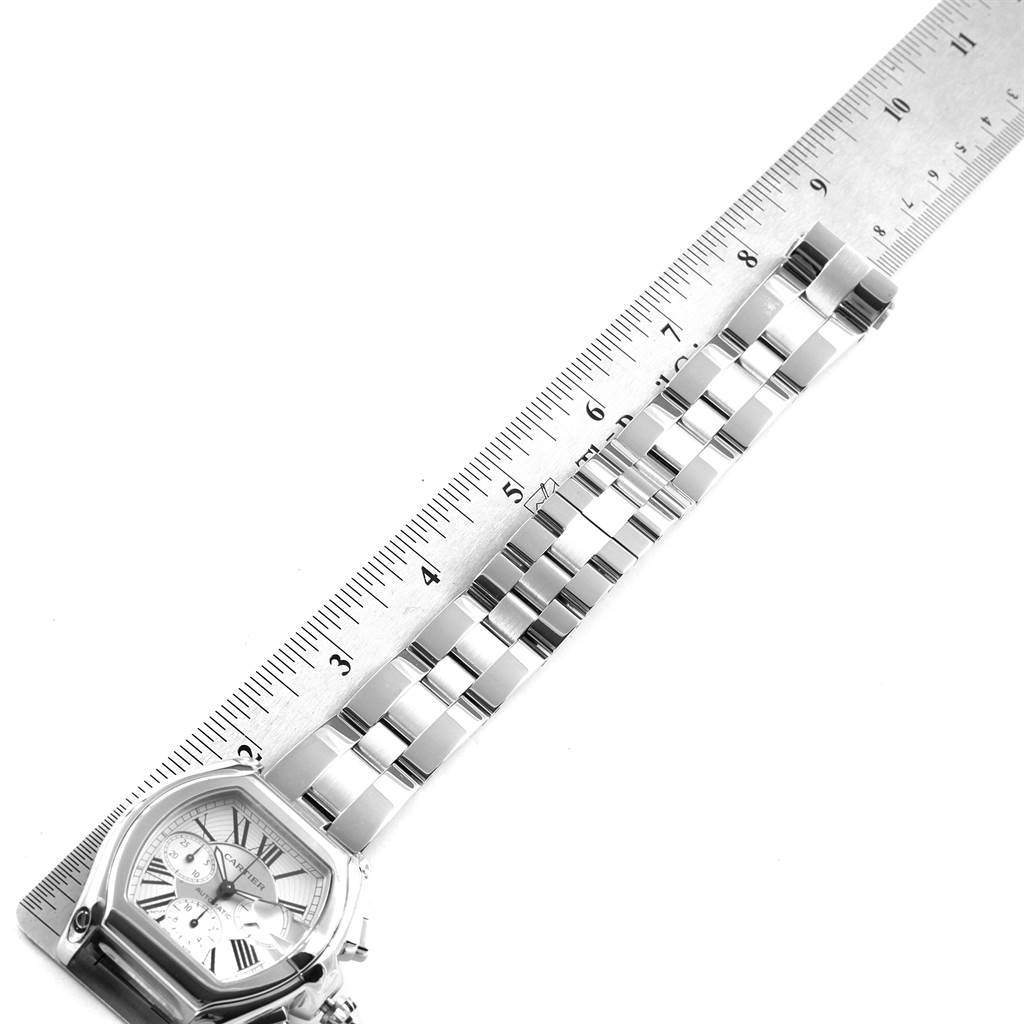 The image shows the face and bracelet of the Cartier Roadster W62019X6 Men's Stainless Steel Silver Dial W62019X6 Men's Stainless Steel Silver Dial watch alongside a ruler for measurement.