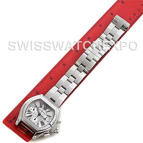 The image shows a Cartier Roadster W62020X6 Men's Stainless Steel Silver Dial W62020X6 Men's Stainless Steel Silver Dial watch laid flat with a focus on the bracelet and face, alongside a red ruler for scale.