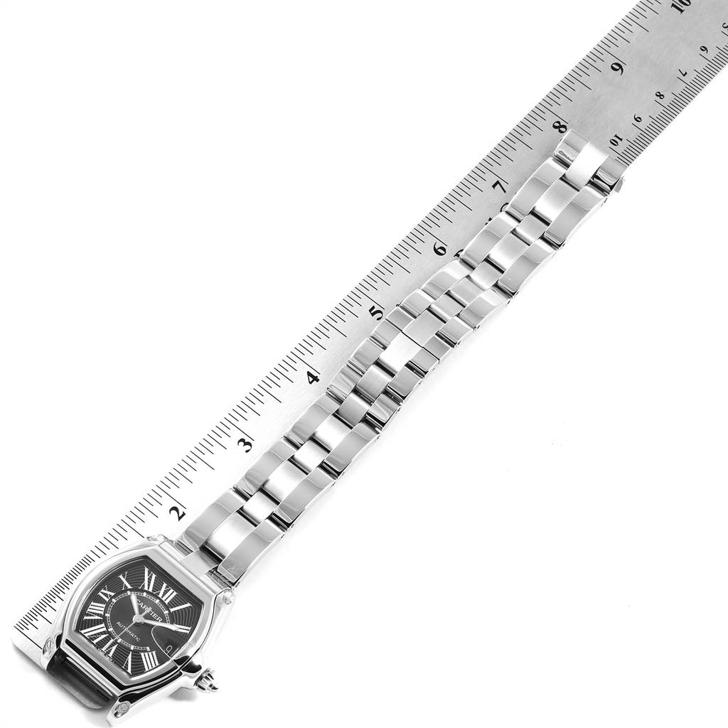 The image shows a Cartier Roadster W62041V3 Men's Stainless Steel Black Dial W62041V3 Men's Stainless Steel Black Dial model watch laying flat with its metal bracelet extended next to a ruler for measurement.