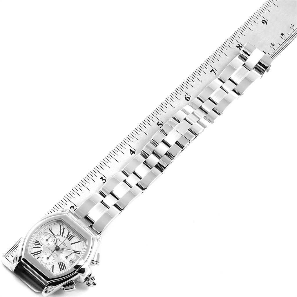 The Cartier Roadster W62019X6 Men's Stainless Steel Silver Dial W62019X6 Men's Stainless Steel Silver Dial watch is shown from an overhead angle, displaying the face and full bracelet against a ruler.