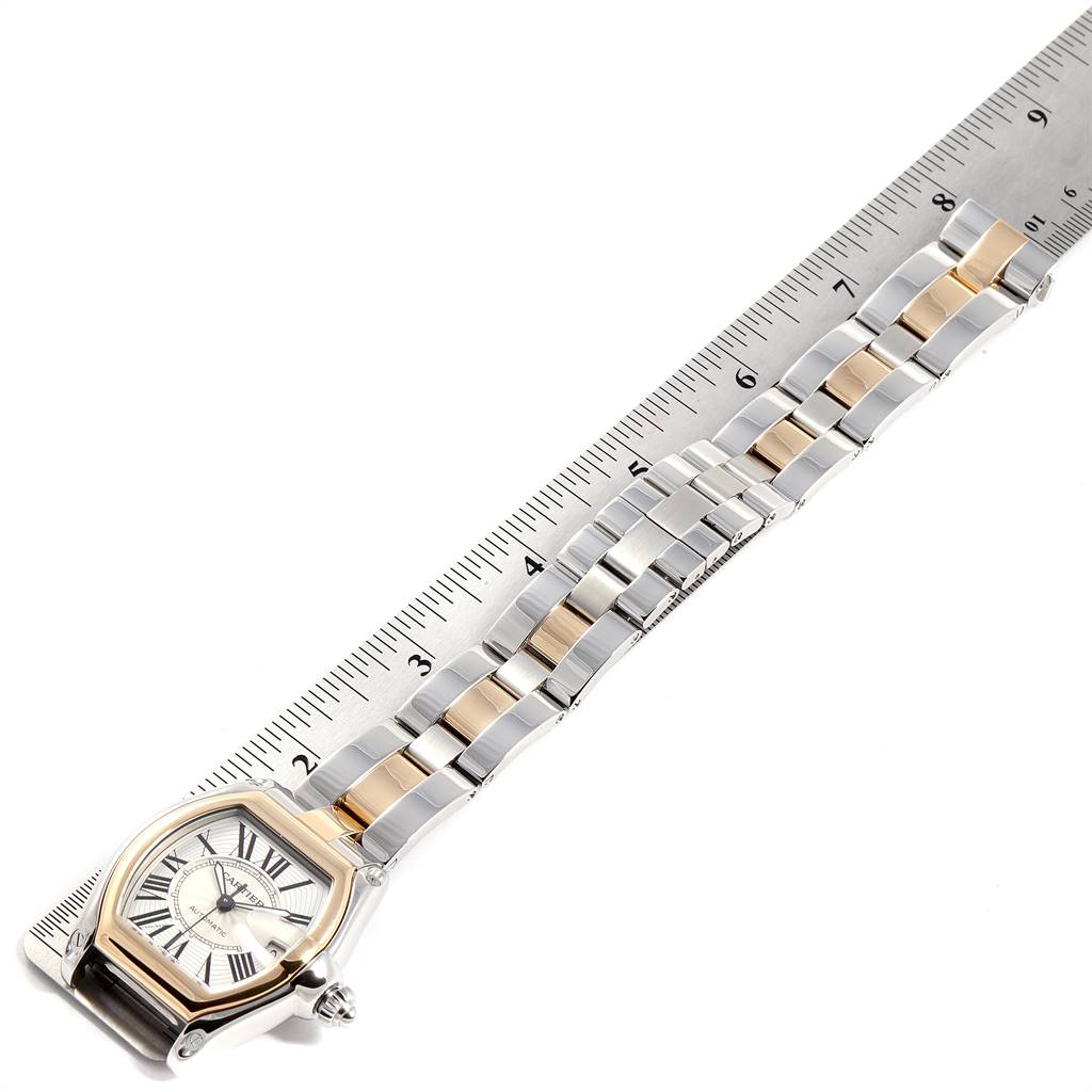 The Cartier Roadster W62031Y4 Men's Steel and Gold (two tone) Silver Dial W62031Y4 Men's Steel and Gold (two tone) Silver Dial watch is shown from a top-down angle, featuring its face, metal band, and partial ruler for scale.