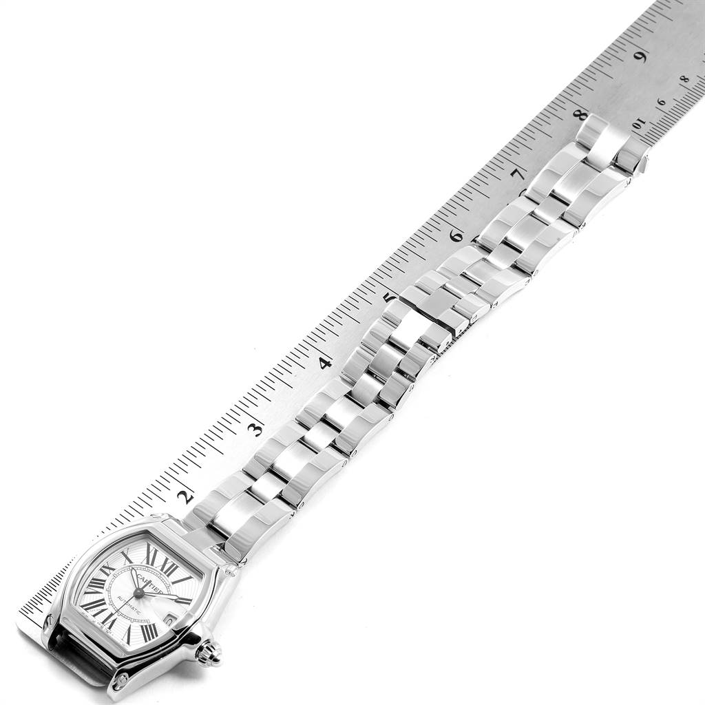 This image shows a top-down view of a Cartier Roadster W62025V3 Men's Stainless Steel Silver Dial W62025V3 Men's Stainless Steel Silver Dial watch, focusing on the face and metal bracelet next to a ruler.