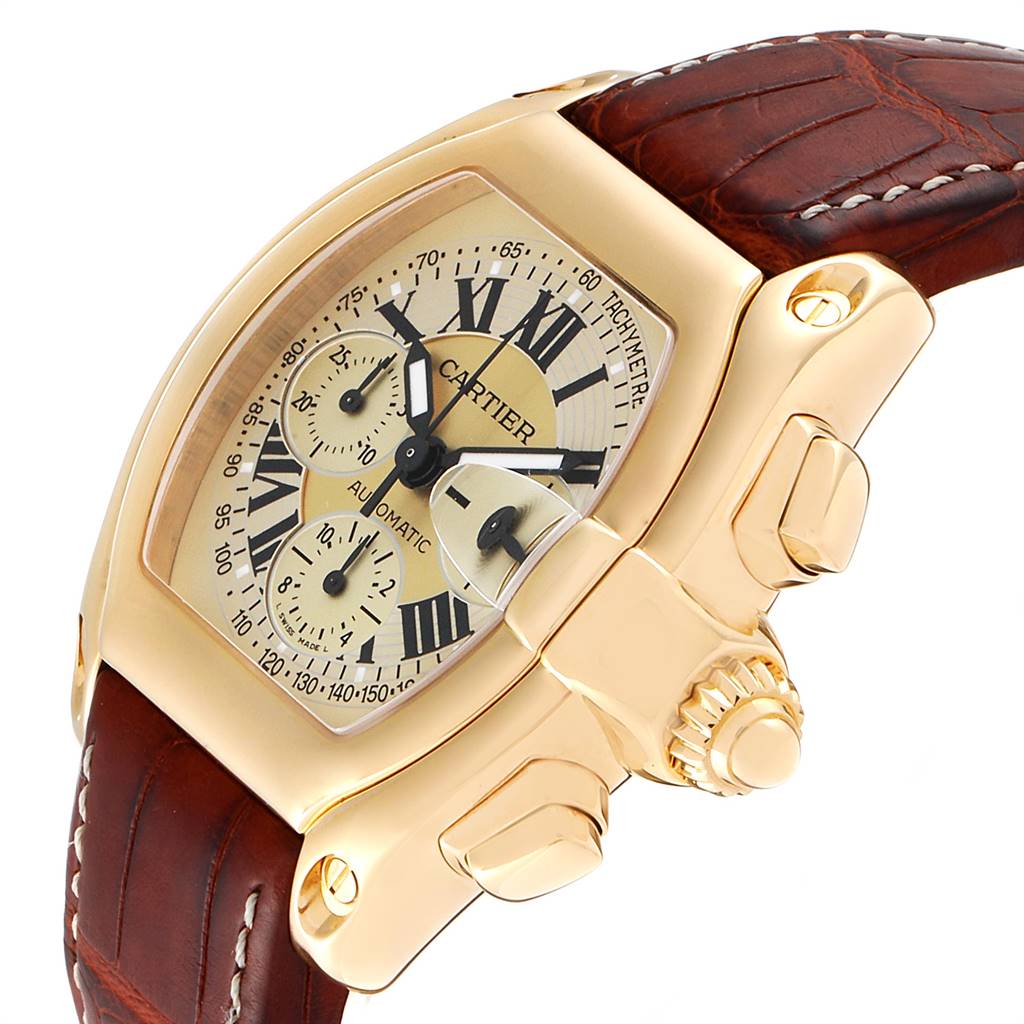 The Cartier Roadster W62021Y3 Men's Yellow Gold Champagne Dial W62021Y3 Men's Yellow Gold Champagne Dial watch is shown at an angle highlighting the gold case, crown, brown leather strap, and detailed dial.