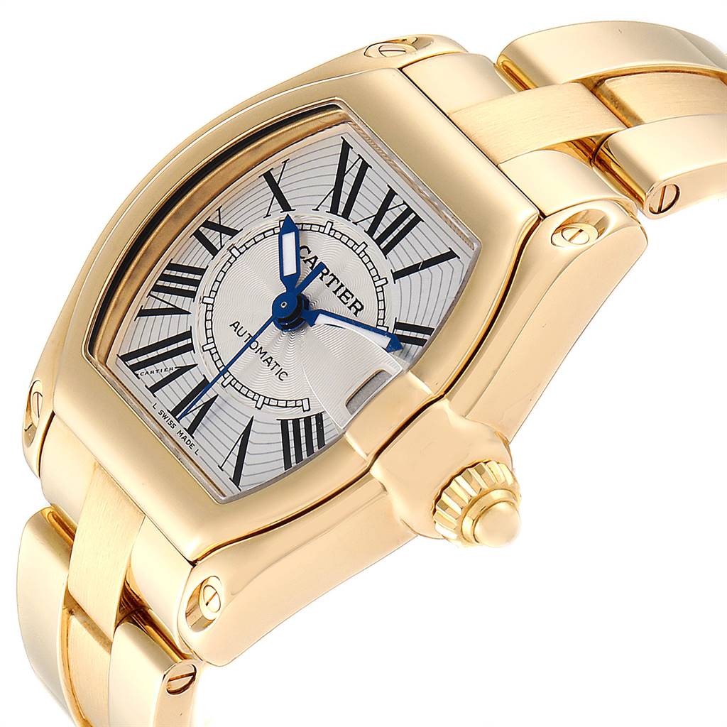 The image shows a close-up of the Cartier Roadster W62005V1 Men's Yellow Gold Silver Dial W62005V1 Men's Yellow Gold Silver Dial watch's dial, crown, and part of the bracelet from a three-quarter angle.