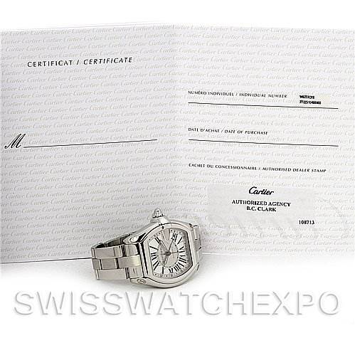 The image shows a Cartier Roadster W62032X6 Men's Stainless Steel Silver Dial W62032X6 Men's Stainless Steel Silver Dial watch placed next to its certificate of authenticity, displayed from a front angle.
