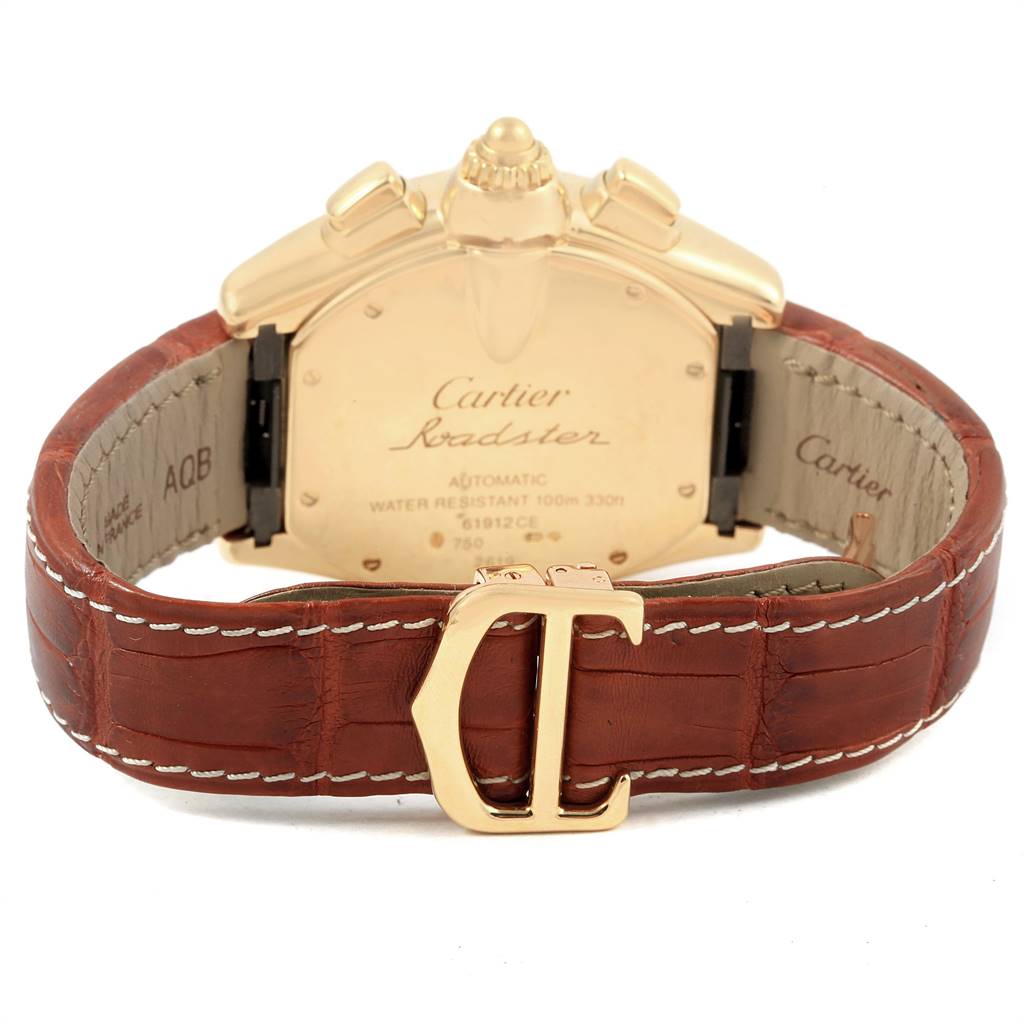 The image shows the back view of a Cartier Roadster W62021Y3 Men's Yellow Gold Silver Dial W62021Y3 Men's Yellow Gold Silver Dial watch, highlighting the case back, crown, and brown leather strap with the Cartier "C" buckle.