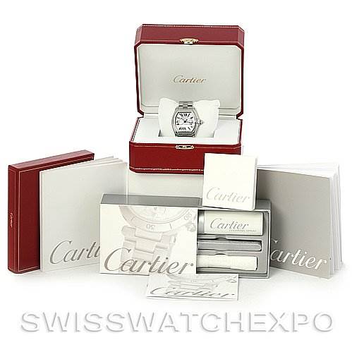 The Cartier Roadster W62025V3 Men's Stainless Steel Silver Dial W62025V3 Men's Stainless Steel Silver Dial watch is shown in its case, along with manuals, a red box, and additional accessories.
