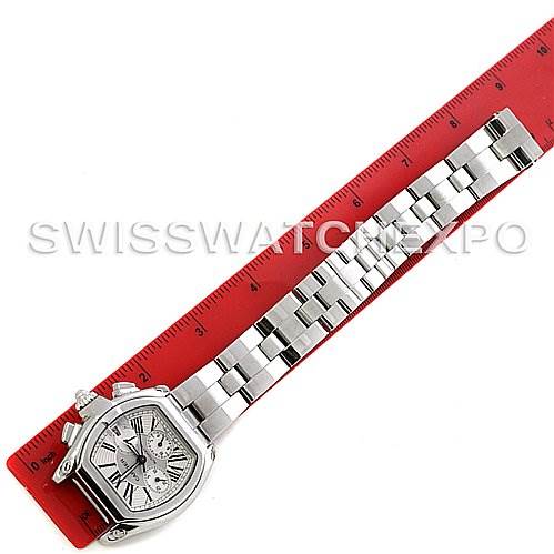 The image shows a Cartier Roadster W62019X6 Men's Stainless Steel Silver Dial W62019X6 Men's Stainless Steel Silver Dial watch laid flat next to a red ruler, displaying the front view of the watch face and its metal bracelet.