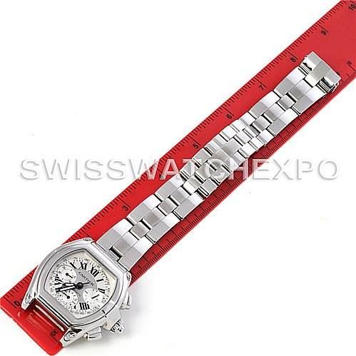 The image shows a Cartier Roadster W62019X6 Men's Stainless Steel Silver Dial W62019X6 Men's Stainless Steel Silver Dial watch laid flat with the full bracelet and dial visible next to a red ruler for scale.