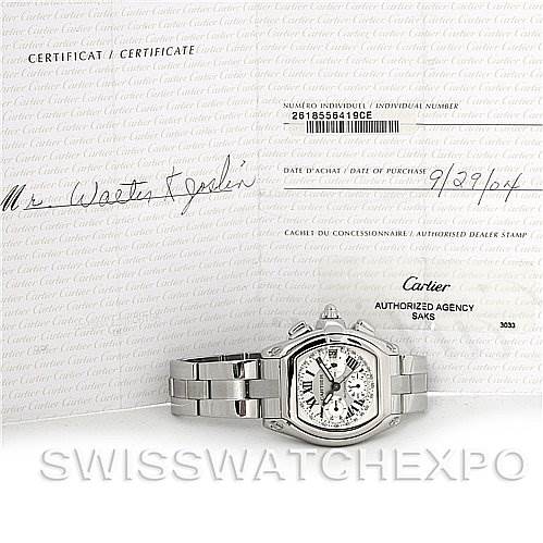 The image shows a Cartier Roadster W62019X6 Men's Stainless Steel Silver Dial W62019X6 Men's Stainless Steel Silver Dial watch from a front angle along with its certification documents.