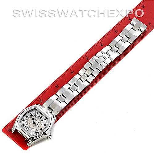 The image shows a Cartier Roadster W62025V3 Men's Stainless Steel Silver Dial W62025V3 Men's Stainless Steel Silver Dial watch laid flat with its band extended next to a red ruler for scale.