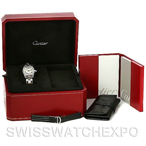 The image shows a Cartier Roadster W62025V3 Men's Stainless Steel Silver Dial W62025V3 Men's Stainless Steel Silver Dial watch in a red box, accompanied by an additional strap and a leather pouch.
