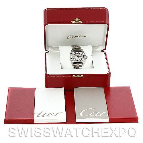 The image shows a Cartier Roadster W62025V3 Men
s Stainless Steel Silver Dial W62025V3 Men
s Stainless Steel Silver Dial watch inside its open red box, alongside accompanying documents and booklets.