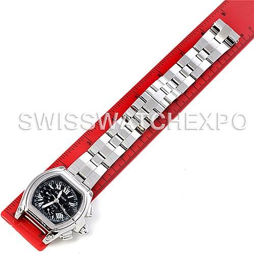 The image shows a Cartier Roadster W62020X6 Men's Stainless Steel Black Dial W62020X6 Men's Stainless Steel Black Dial model watch, laid flat with its metal bracelet fully extended next to a red ruler for scale.