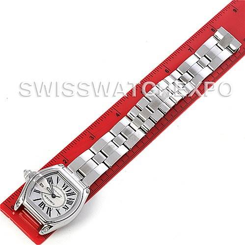 The image shows a top-down view of a Cartier Roadster W62025V3 Men's Stainless Steel Silver Dial W62025V3 Men's Stainless Steel Silver Dial watch with a silver metal bracelet placed against a red ruler for measurement.