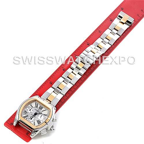 The Cartier Roadster W62027Z1 Men's Steel and Gold (two tone) Silver Dial W62027Z1 Men's Steel and Gold (two tone) Silver Dial model watch is shown from a top view, highlighting its face and metal bracelet on a red ruler.
