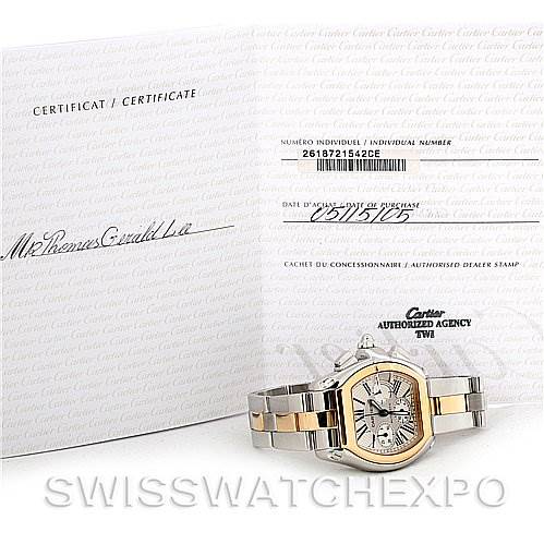 The image shows a Cartier Roadster W62027Z1 Men's Steel and Gold (two tone) Silver Dial W62027Z1 Men's Steel and Gold (two tone) Silver Dial watch set against its certificate with the watch lying flat, showcasing its face and bracelet.