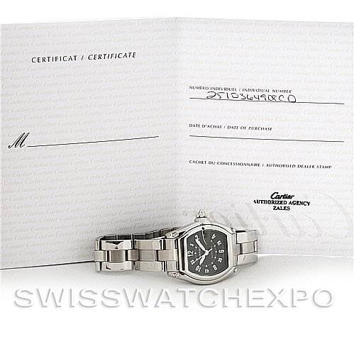 The image shows the Cartier Roadster W62004V3 Men's Stainless Steel Black Dial W62004V3 Men's Stainless Steel Black Dial watch lying flat, alongside its open certification booklet from Cartier.